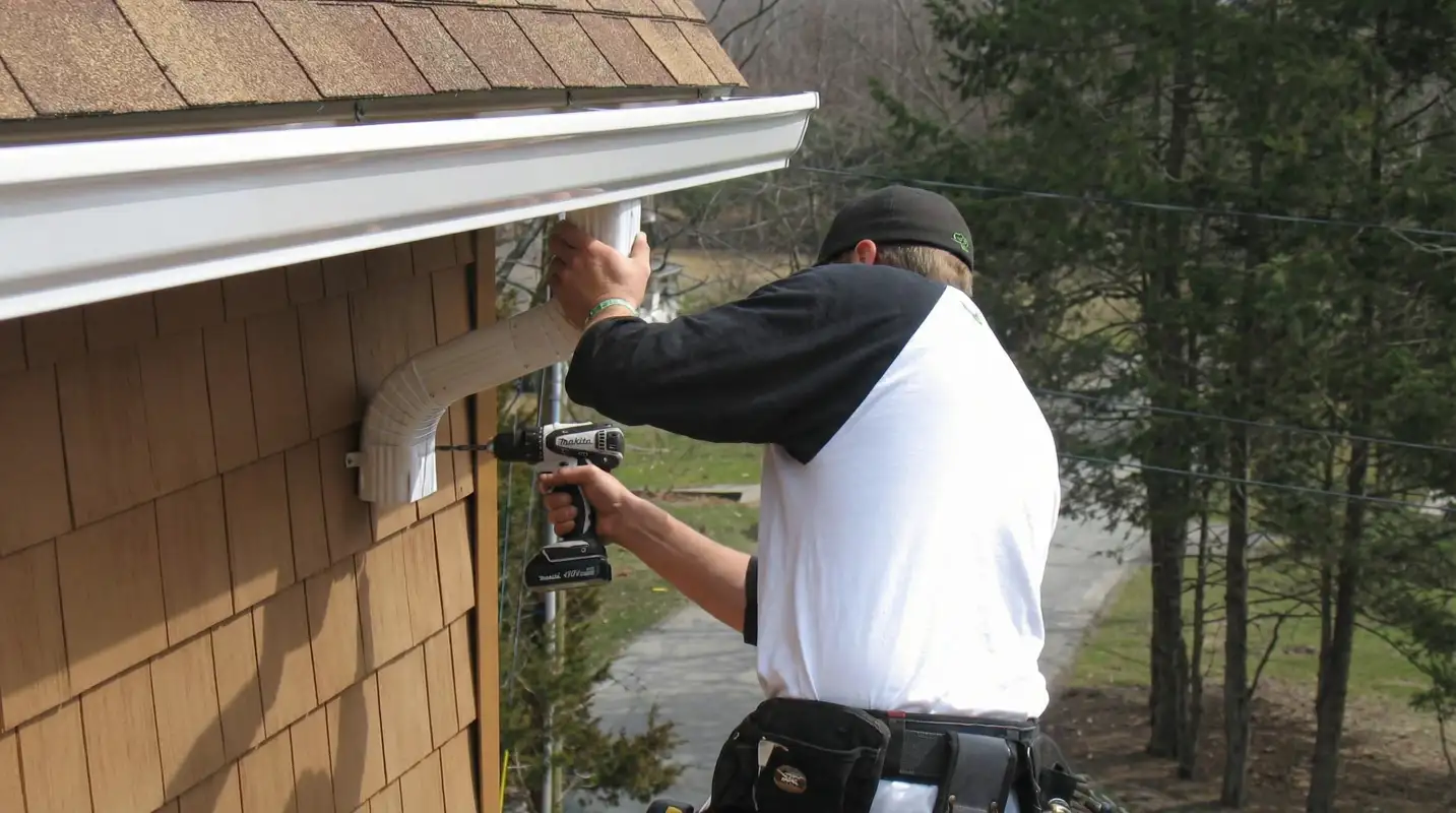 Professional contractor installing tan vinyl siding panels on a residential home exterior in Tucson, AZ